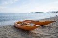 Two colorful orange kayaks on a sandy beach ready for paddlers in sunny day. Several orange recreational boats on the Royalty Free Stock Photo