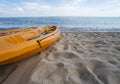 Two colorful orange kayaks on a sandy beach ready for paddlers in sunny day. Several orange recreational boats on the Royalty Free Stock Photo