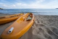 Two colorful orange kayaks on a sandy beach ready for paddlers in sunny day. Several orange recreational boats on the Royalty Free Stock Photo