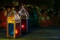 Two colorful oriental Lamp lanterns burn with candles with color