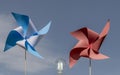 Two colorful paper pinwheels and a lit light bulb, make the concept of clean wind energy, against the blue sky Royalty Free Stock Photo