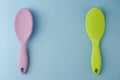 Two colorful plastic hairbrushes on pastel blue Royalty Free Stock Photo