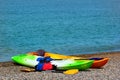 Two colorful sea kayaks with paddles and life jackets on stony beach Royalty Free Stock Photo