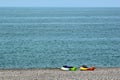 Two colorful sea kayaks with paddles and life jackets on stony beach Royalty Free Stock Photo