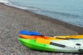 Two colorful sea kayaks with paddles on stony beach Royalty Free Stock Photo