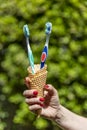 Two toothbrushes with toothpaste are placed inside a cone, like those for ice cream Royalty Free Stock Photo