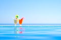 Two Colorful Tropical Cocktails near the Swimming Pool on Background of Warm Blue Sea. Exotic Summer Vacation. Royalty Free Stock Photo