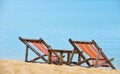 Two colorful wooden lounge chairs on sand beach Royalty Free Stock Photo