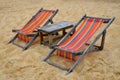 Two colorful wooden lounge chairs on sand beach Royalty Free Stock Photo