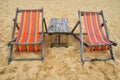 Two colorful wooden lounge chairs on sand beach Royalty Free Stock Photo