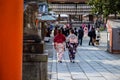 Two colorful young japanese girls dressed in traditional kimonos walking in temple