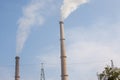 Factory smokestacks billowing against sky