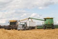 Two combines loading a semi truck with grain