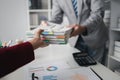 Two company employees handing over papers to each other, marketing staff handing over marketing analysis papers to department Royalty Free Stock Photo