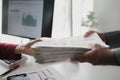 Two company employees handing over papers to each other, marketing staff handing over marketing analysis papers to department Royalty Free Stock Photo