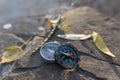 Two compasses lie on stones in the rays of the sun. Royalty Free Stock Photo