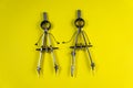 Two compasses on a yellow background Royalty Free Stock Photo