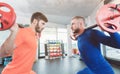 Two competitive young man lifting weights in the gym