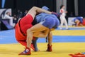 Two competitors participating in the traditional martial art of Sambo engaged in an intense match