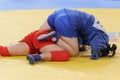 Two competitors participating in the traditional martial art of Sambo engaged in an intense match