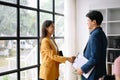 Two confident Asian business man and woman shaking hands during a meeting in the office, success, dealing, greeting and partner Royalty Free Stock Photo