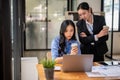 Two confident Asian businesswomen are using a laptop together, planning and working on a project Royalty Free Stock Photo