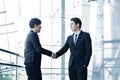 Confident businessmen shaking hands and smiling