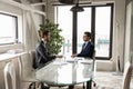 Two confident businessmen sitting at table in boardroom, discussing project Royalty Free Stock Photo