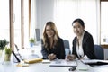 Two businesswoman sitting together in office and smiling to camera. Royalty Free Stock Photo