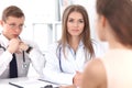 Two confident friendly doctors sitting at the table and listen to the patient`s history . Medical and health care