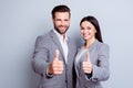 Two confident smiling businesspeople in formalwear showing thumb Royalty Free Stock Photo