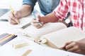 Two confident students reading a book or doing homework together while sitting at the home Royalty Free Stock Photo