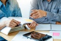 Two confident students reading a book or doing homework together while sitting at the home Royalty Free Stock Photo