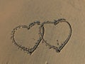 Two connected Hearts drawn on the sand of a beach Royalty Free Stock Photo