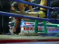 Two connermen standing inside a boxing ring trainer / coach quickly stretching, massaging, and administer to the Thai boxing