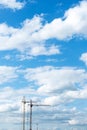 Two construction cranes against the blue cloudy sky. Tower crane for lifting loads in the construction of buildings. Royalty Free Stock Photo