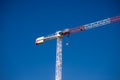 Two construction tower cranes at a construction site against a blue sky with clouds. Modern high-rise office building Royalty Free Stock Photo