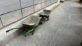 Two Wheelbarrows Facing Each Other on Pavement Royalty Free Stock Photo