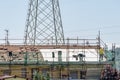 Two construction workers cover the roof of a large apartment building with the typical red brick tiles