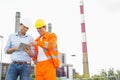 Two construction workers discussing over tablet PC at industry