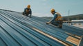 Two Construction Workers Installing Metal Roofing on a Building Royalty Free Stock Photo