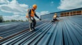 Two Construction Workers Installing Metal Roofing On A Building Royalty Free Stock Photo