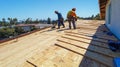 Two Construction Workers Laying Plywood on a Roof Royalty Free Stock Photo