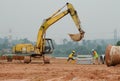 Two construction workers lifting concrete slab using the excavator