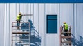 Two Construction Workers on Scaffolding Installing Metal Siding on a Building Royalty Free Stock Photo