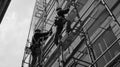 Two Construction Workers on Scaffolding Working on a Building Royalty Free Stock Photo