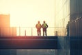 Two Construction Workers Silhouetted Against a Bright Sky at Sunset Royalty Free Stock Photo