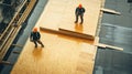 Two Construction Workers Standing on Plywood Sheets on a Roof Royalty Free Stock Photo