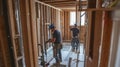 Two Construction Workers Working Inside a House Under Construction Royalty Free Stock Photo