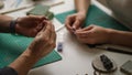 two contemporary working together in jewelry workshop. Master and apprentice. Young male assistant and female jeweler